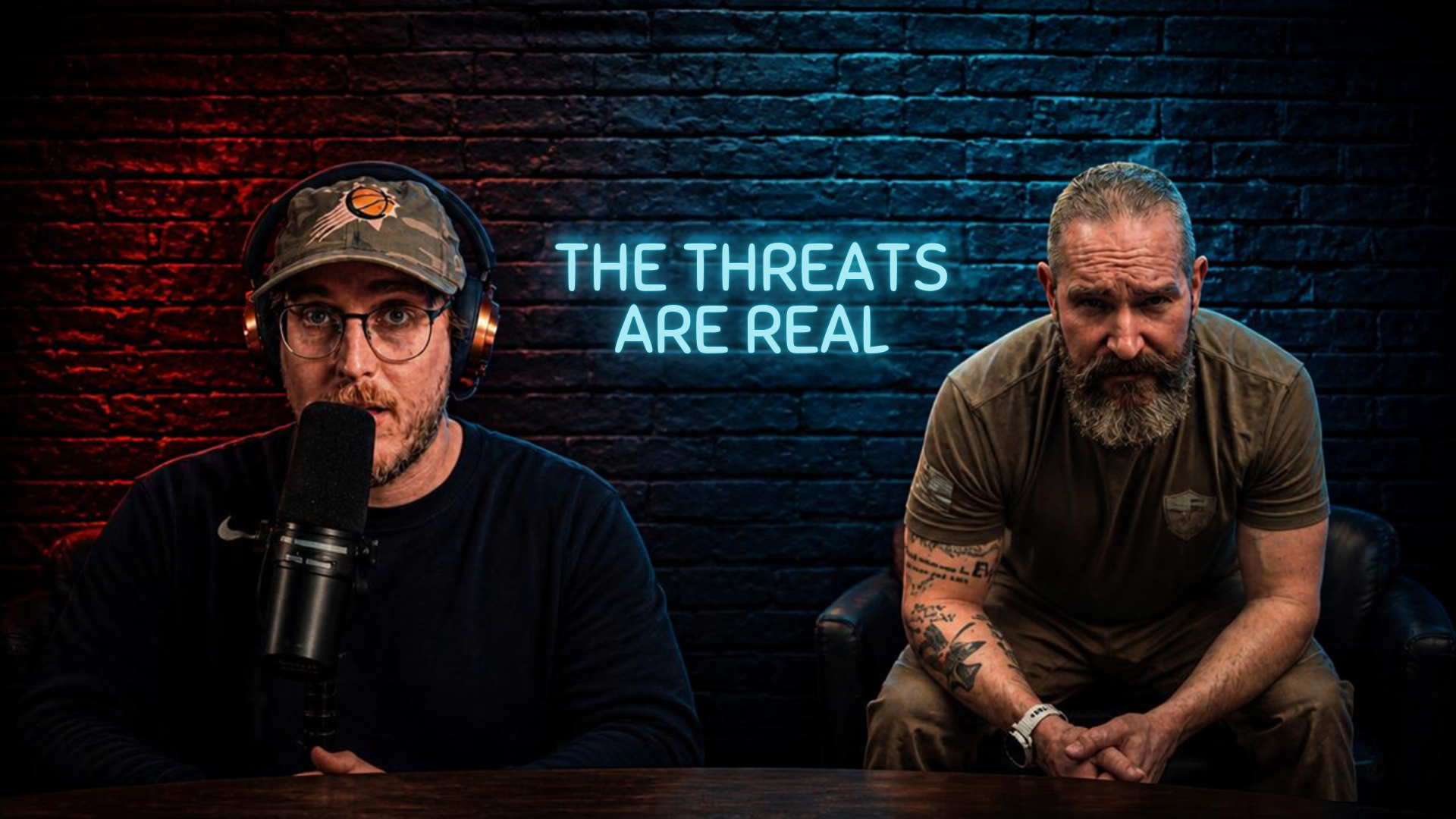 Ryan McDonough, in a Phoenix Suns cap and headphones, speaks into a studio mic beside a bearded guest with tattooed arms. A blue neon sign on the brick wall behind them reads “THE THREATS ARE REAL.”